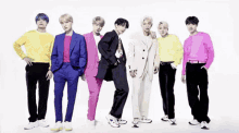 a group of young men are standing next to each other wearing colorful suits and sweaters .