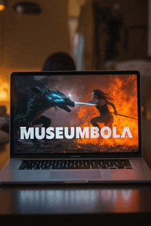 a laptop screen shows a woman fighting a dragon and the words museumbola