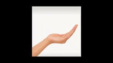 a hand is holding a black diamond shaped object in it