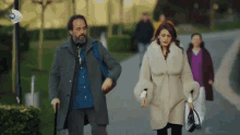 a man and a woman are walking down a street