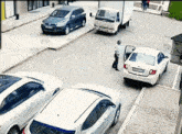 a man is standing in front of a white car with a license plate that starts with the letter a