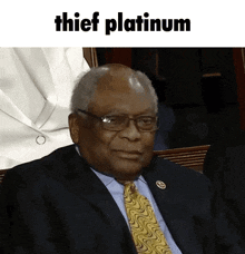 a man in a suit and tie is sitting in front of a sign that says thief platinum
