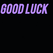 a woman with her fingers crossed is in front of a sign that says good luck