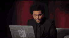 a man in a suit is using a laptop computer .