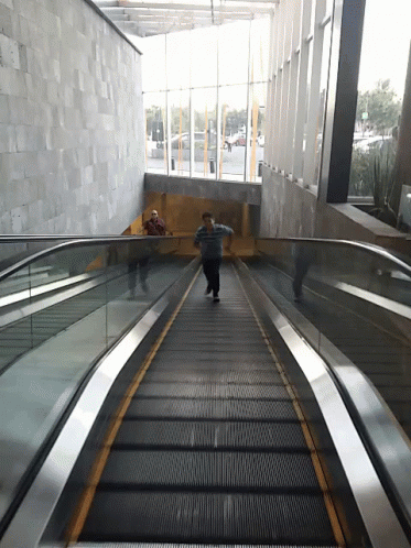Эскалатор метрополитена поднимает стоящего
