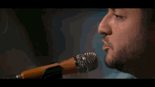 a man is singing into a microphone while playing a guitar