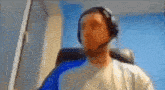 a man wearing headphones is sitting in a chair .