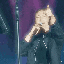 a man is singing into a microphone on a stage .