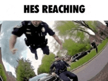 two police officers are jumping over a car with the words hes reaching above them .