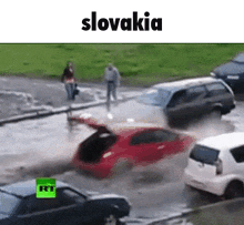 a red car is driving through a puddle of water in slovakia .