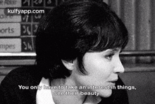 a black and white photo of a woman talking to someone .