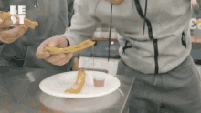 a person holding a piece of food on a plate that says best products on it