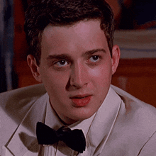 a young man wearing a tuxedo and bow tie
