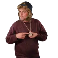 a man wearing a maroon sweater and a black hat holds a dollar sign necklace