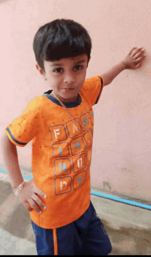 a young boy wearing an orange shirt that says fashion no boy