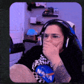 a woman wearing glasses and headphones is covering her mouth