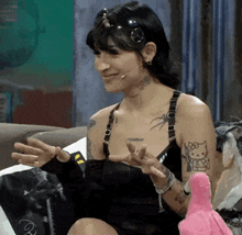 a woman with a hello kitty tattoo is sitting on a couch