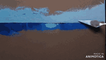a painting is being painted with a spatula and the words made in animotica are on the bottom