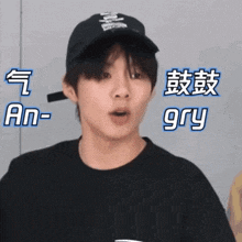 a young man wearing a black hat and a black t-shirt with chinese writing on it .