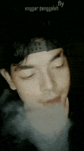 a close up of a man smoking a cigarette