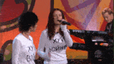 a woman singing into a microphone next to a keyboard that says virus