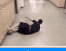 a person is laying on their back on a hallway floor .