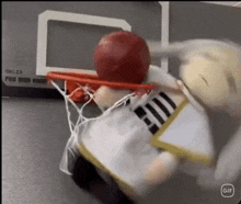 a stuffed animal is dunking a basketball into a basketball hoop .