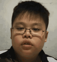 a young boy wearing glasses and a white shirt