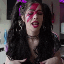 a woman with a star painted on her face is wearing a choker necklace .