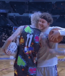 a man in a number 11 jersey is holding a basketball with another man