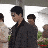 a man in a suit is smiling while standing next to another man in a suit
