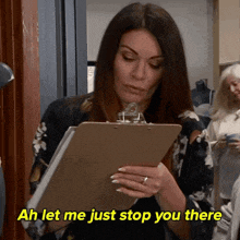 a woman holding a clipboard with the words ah let me just stop you there below her