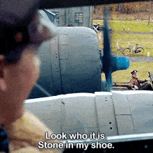 a man is looking out of a car window at a plane and says look who it is stone in my shoe