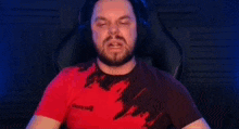 a man with a beard and headphones is sitting in a chair and making a funny face .