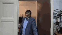 a man in a suit is walking through a doorway