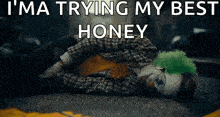 a clown is laying on the ground with the words `` i 'm a trying my best honey '' written on it .
