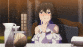 a girl with long black hair is sitting at a table with her hand on her face