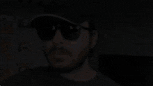 a man with a beard is wearing sunglasses and a hat