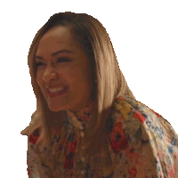 a woman in a floral shirt is smiling and looking away from the camera