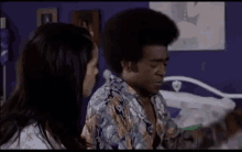 a man with an afro is talking to a woman