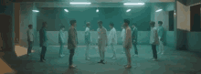 a group of young men are dancing in a dark room in a dark room .