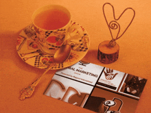 a business card for bal marketing sits next to a cup of tea and a spoon