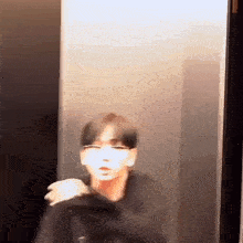 a blurry picture of a man standing in an elevator .