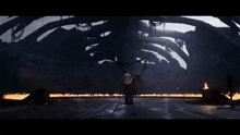 a group of dragons are standing in a dark room with flames