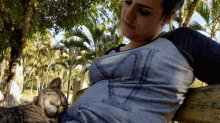 a woman with a cat on her lap and a shirt that says ' a ' on it