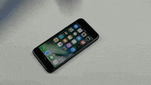 an iphone is being smashed by a hammer on a white surface .