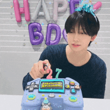 a person lighting a candle on a cake that says happy bday