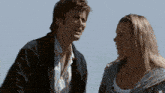 a man and a woman standing next to each other smiling