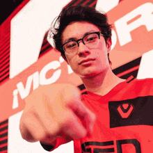 a man wearing glasses and a red shirt with the letter p on it