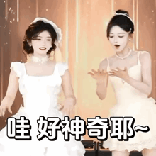 a couple of women in white dresses are dancing together .